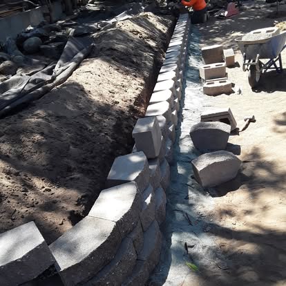 A retaining wall being built up course by course.
